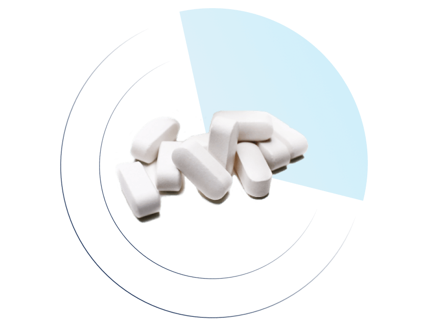 Pile of white oblong tablets placed in front of a blue quarter-circle segment and concentric dark blue arcs on a black background.